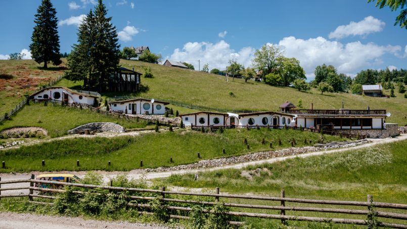 Sat rustic cu case pe deal, grădini verzi și panorama panoramică