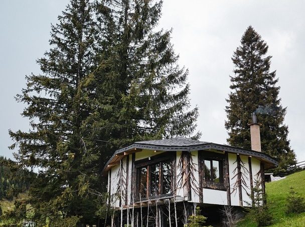 Casuta Con - exterior panoramic din alt unghi, casă modernă cu design unic și zonă jardiniere într-un mediu rural pitoresc