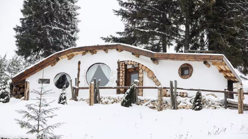 Winter cottage featuring round windows and snow-covered surroundings