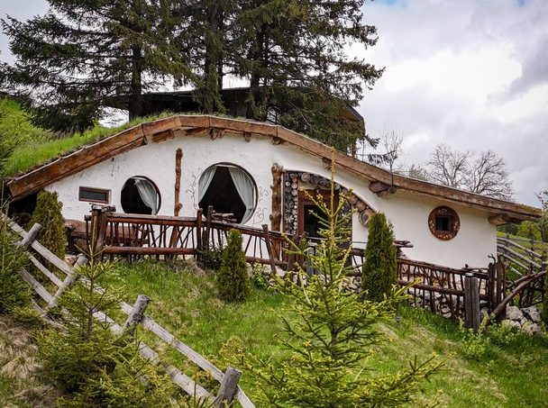 Fatada camerei Nr. 1 - intrare principala, decor natural cu padure, detalii arhitecturale cu stanci și flori